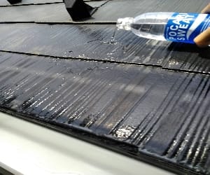 屋根に水をかける様子